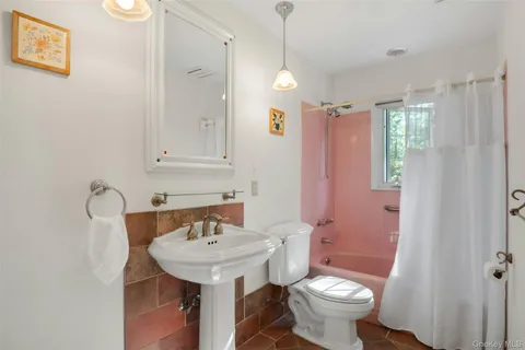 a bathroom with a sink toilet and a mirror