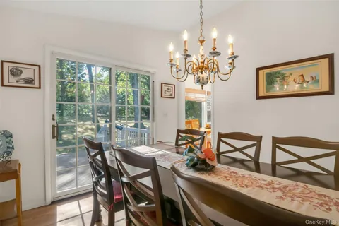 a view of a dining room with furniture a chandelier and wooden floor