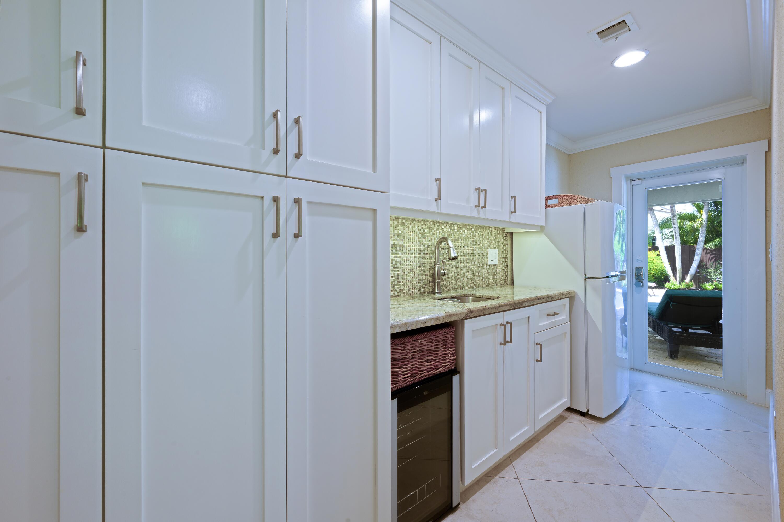 4535 Oak Tree Court Delray Beach, FL 33445 - Photo 15 of 43 a kitchen with a refrigerator and cabinets