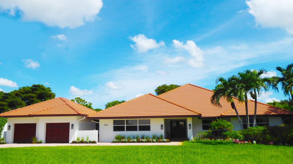 4535 Oak Tree Court Delray Beach, FL 33445 - Photo 2 of 43 a front view of a house with a garden and yard