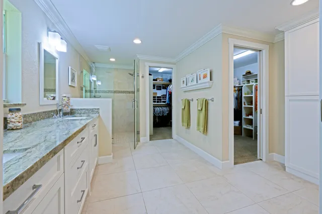 a spacious bathroom with a granite countertop sink and a mirror