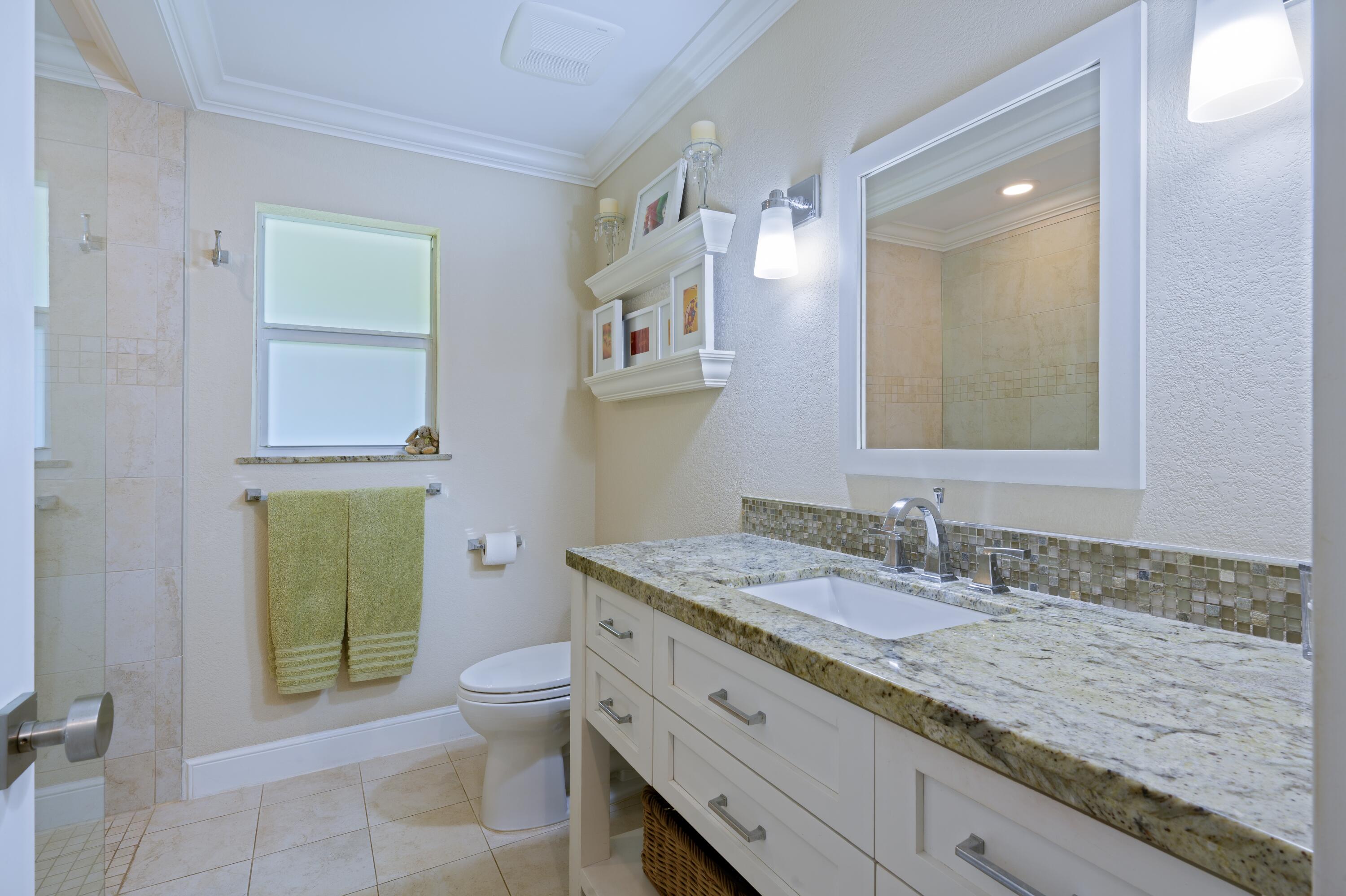 4535 Oak Tree Court Delray Beach, FL 33445 - Photo 23 of 43 a bathroom with a granite countertop toilet sink and mirror