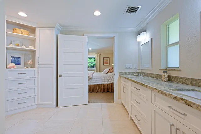 a spacious bathroom with a granite countertop sink and a mirror