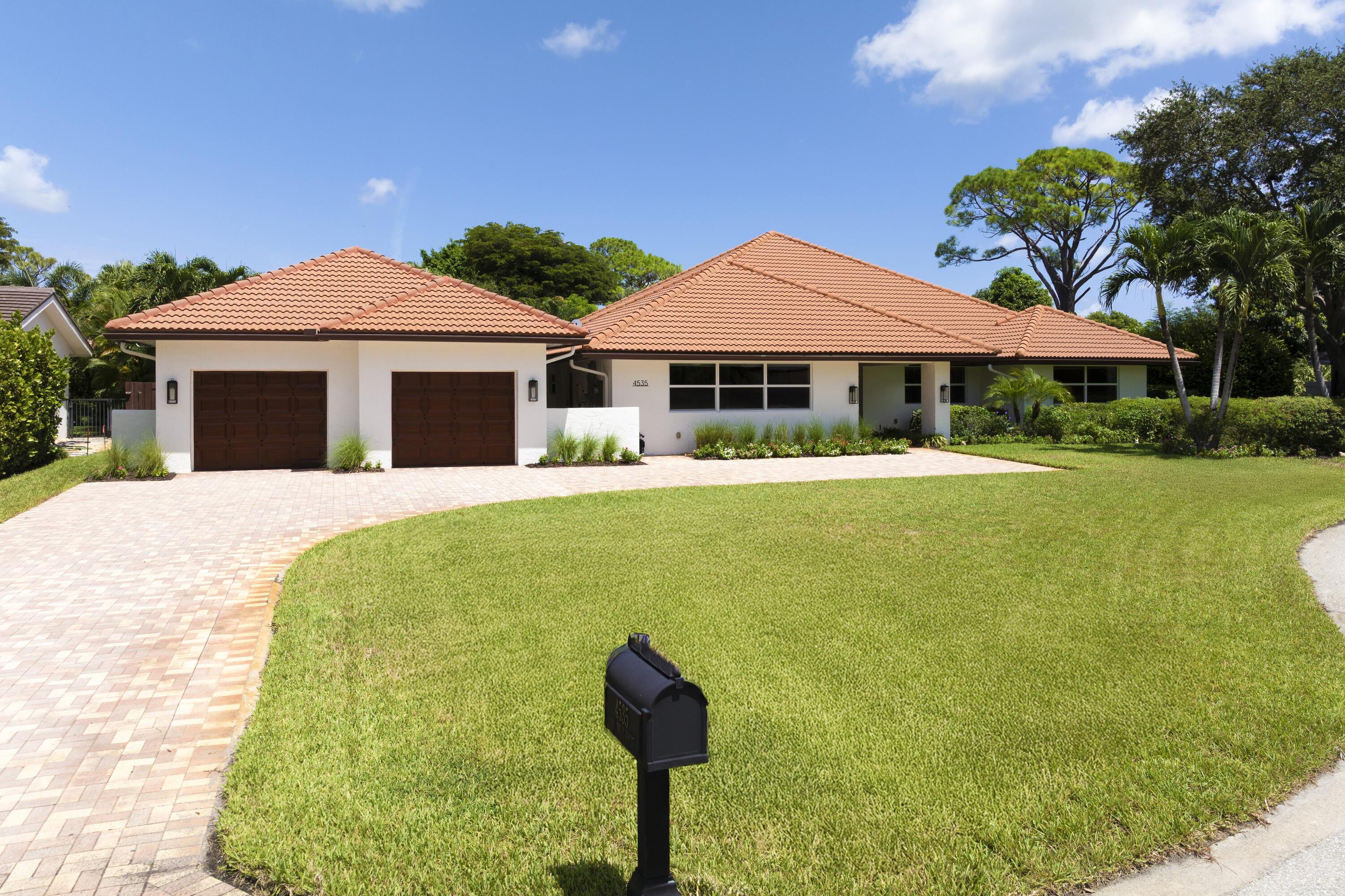 4535 Oak Tree Court Delray Beach, FL 33445 - Photo 4 of 43 a front view of a house with a yard