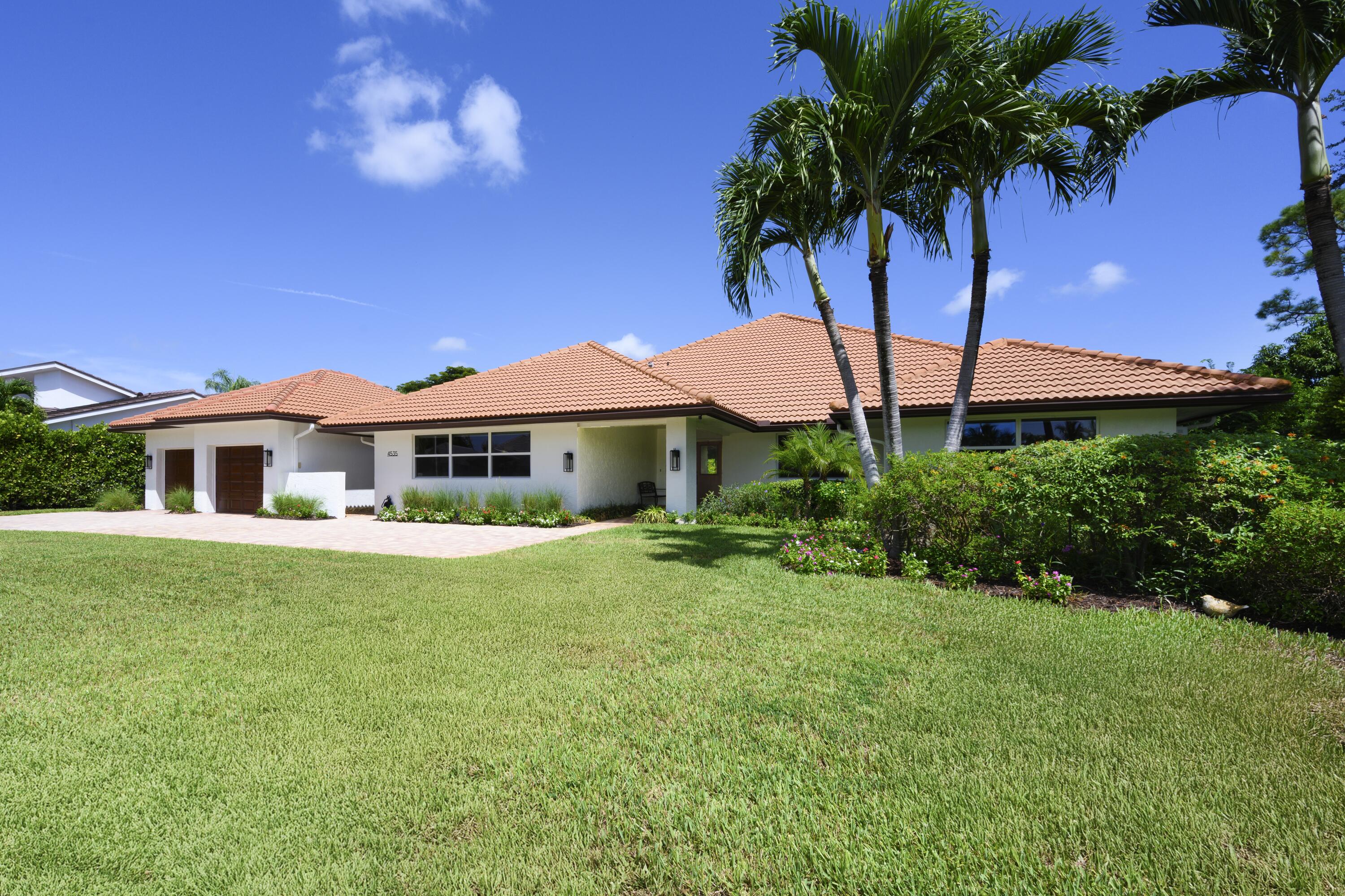 4535 Oak Tree Court Delray Beach, FL 33445 - Photo 5 of 43 a front view of a house with a yard table and chairs