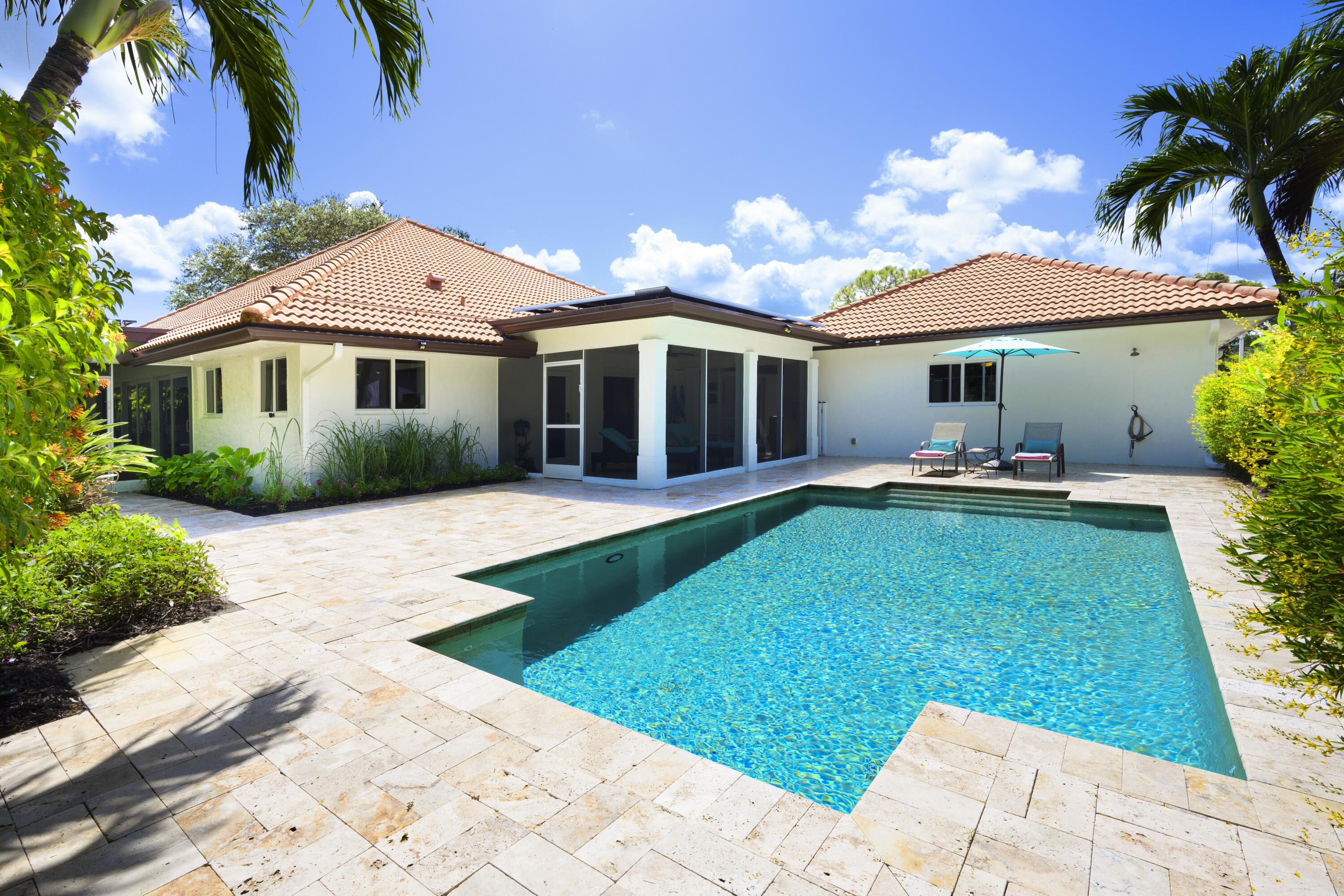 4535 Oak Tree Court Delray Beach, FL 33445 - Photo 6 of 43 a front view of a house with garden