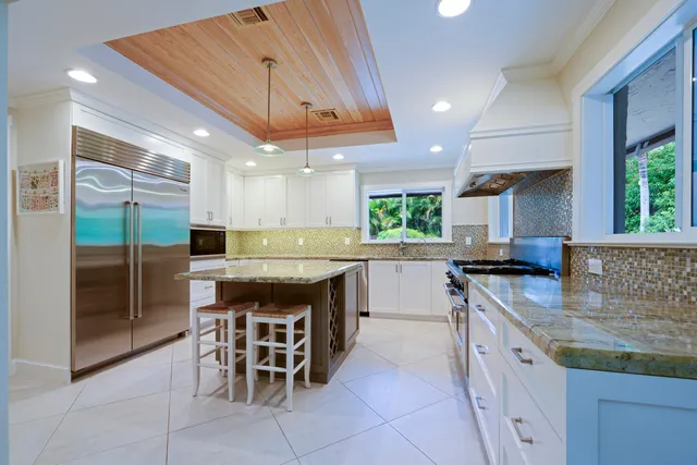 a kitchen with stainless steel appliances granite countertop table chairs sink and cabinets