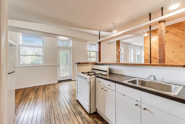 a kitchen with white cabinets stove and sink