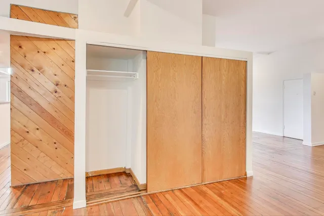 a view of a room with wooden floor staircase and a hallway