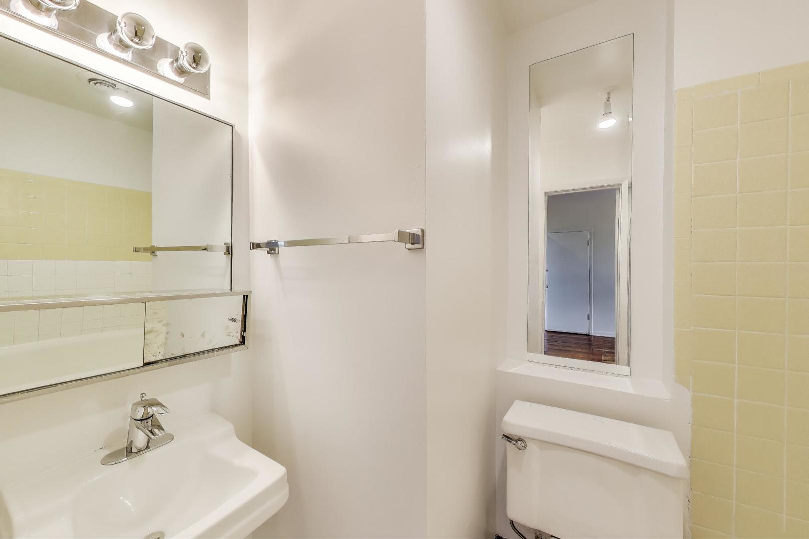 1906-1908 South Halsted Street, Unit 2R Chicago, IL 60608 - Photo 20 of 23 a bathroom with a sink mirror and toilet