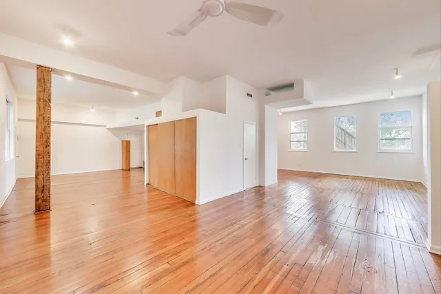a view of empty room with wooden floor