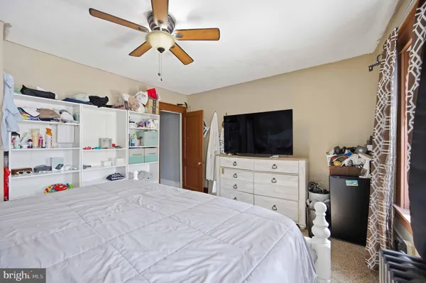 a bedroom with a bed a flat screen tv and a chandelier