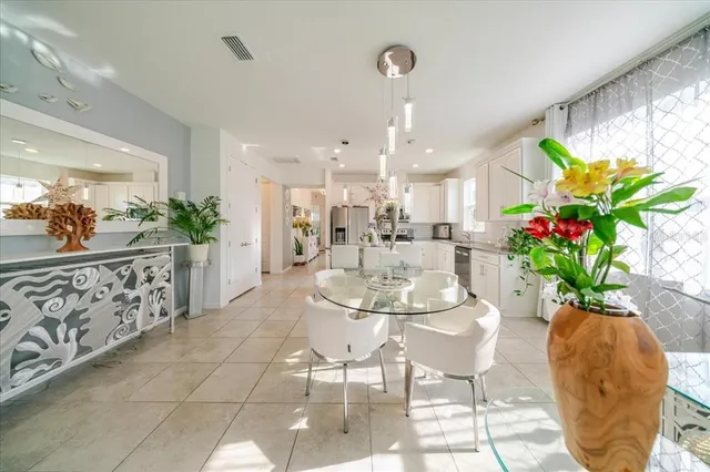 a kitchen with stainless steel appliances granite countertop a refrigerator a sink dishwasher and white cabinets with wooden floor