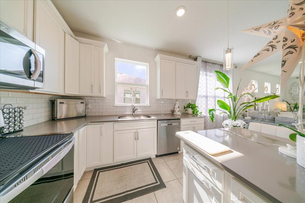 1833 Spring Shower Circle Kissimmee, FL 34744 - Photo 30 of 51 a kitchen with a sink stove and cabinets