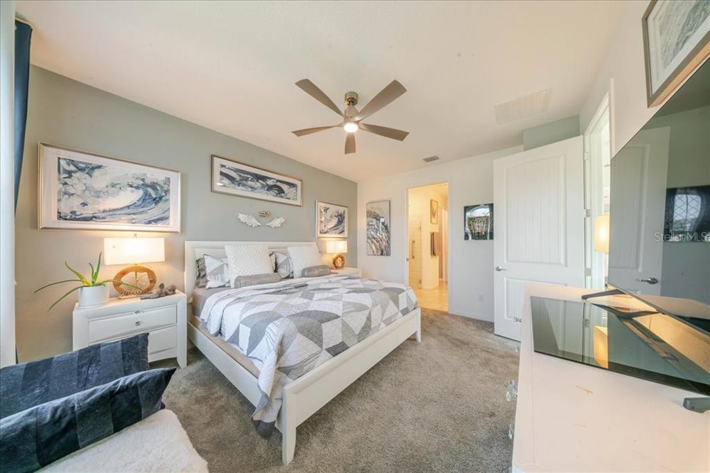 1833 Spring Shower Circle Kissimmee, FL 34744 - Photo 39 of 51 a bedroom with a bed and a chandelier