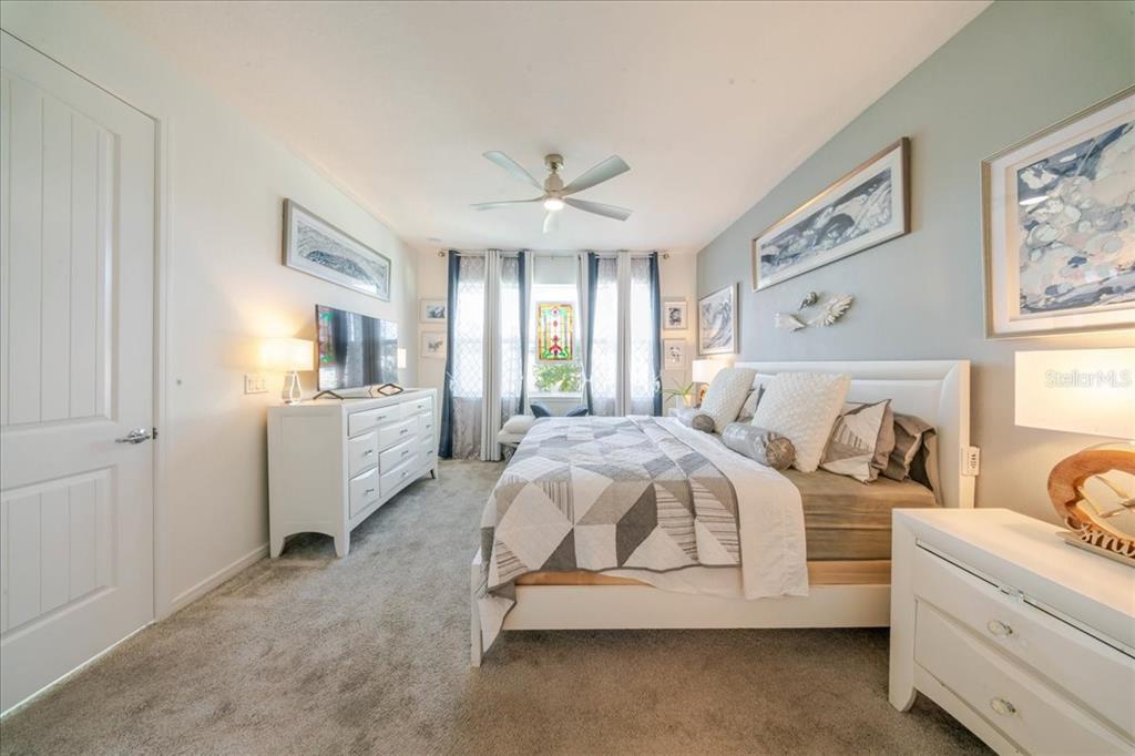 1833 Spring Shower Circle Kissimmee, FL 34744 - Photo 44 of 51 a spacious bedroom with a bed a couch and a window