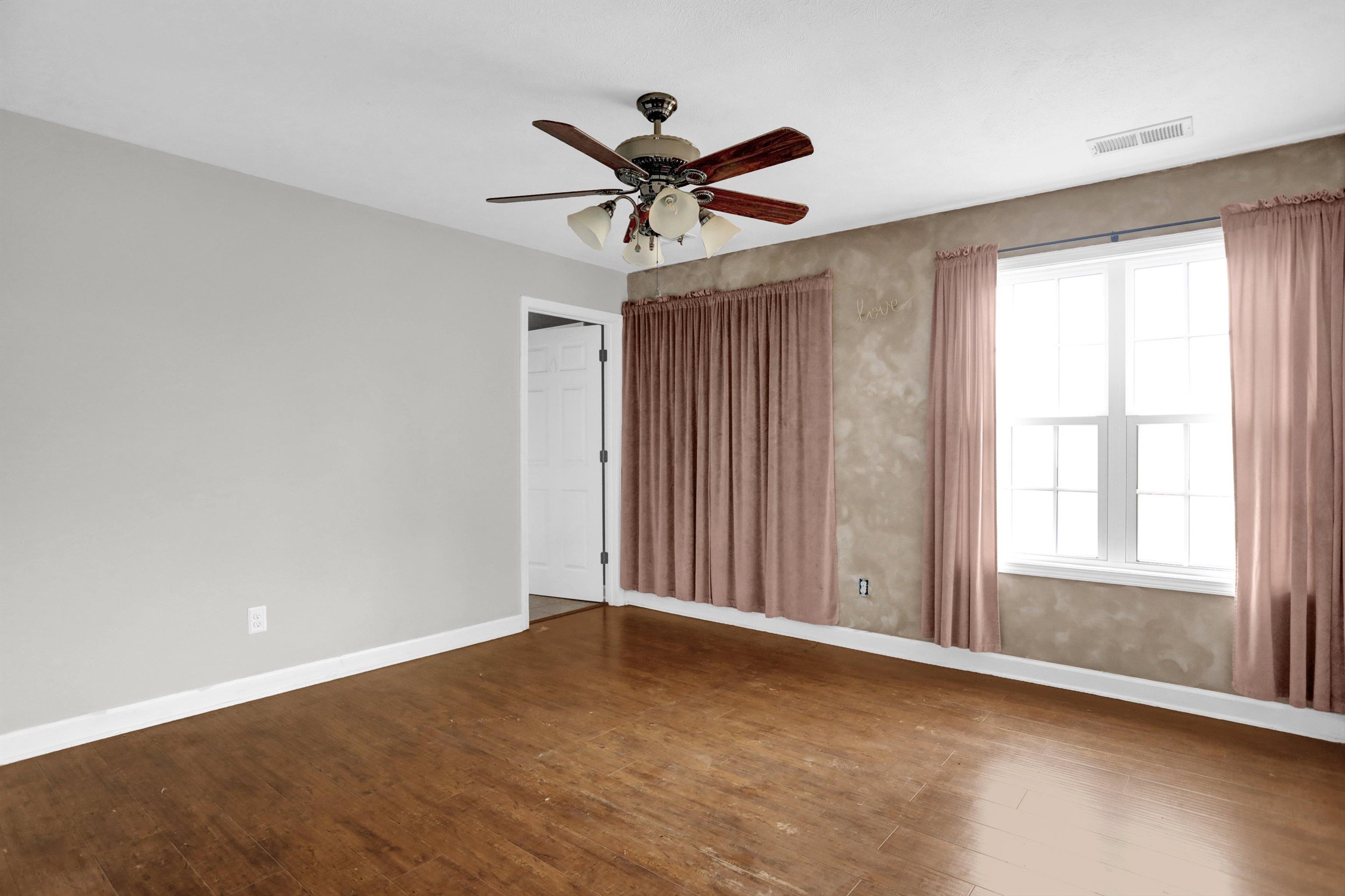 186 King Road Selmer, TN 38375 - Photo 18 of 30 an empty room with wooden floor fan and windows