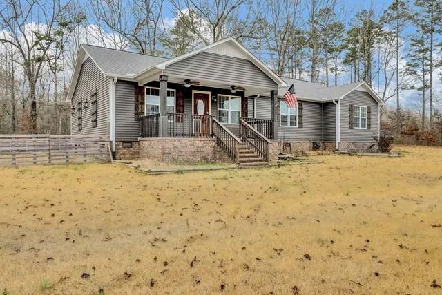 a view of wooden house with large trees