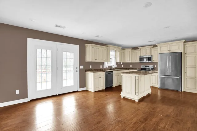 a kitchen with granite countertop white cabinets and stainless steel appliances