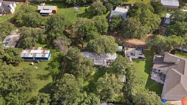 an aerial view of residential house with outdoor space and trees all around