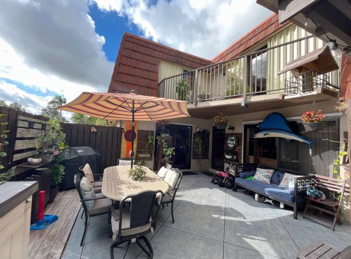8282 Boca Rio Drive Boca Raton, FL 33433 - Photo 4 of 29 a view of a patio with a table and chairs under an umbrella