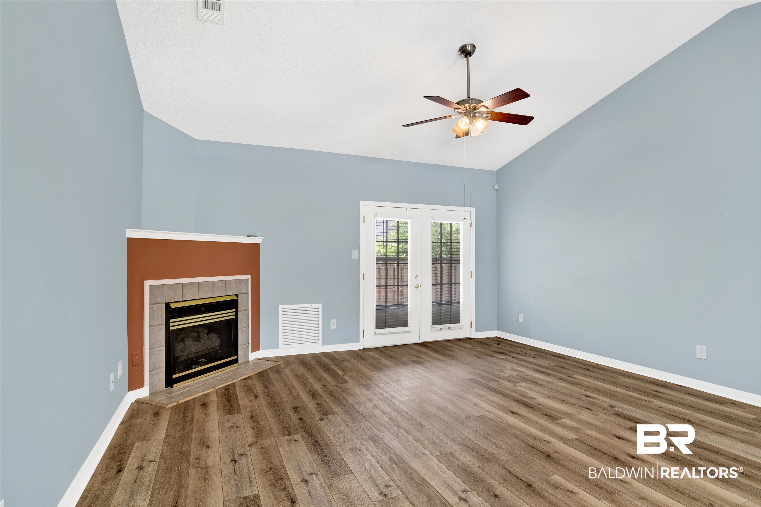 1258 Sutton Court, Unit 4 Mobile, AL 36609 - Photo 2 of 19 Unfurnished living room featuring a ceiling fan, french doors, wood finished floors, and visible vents