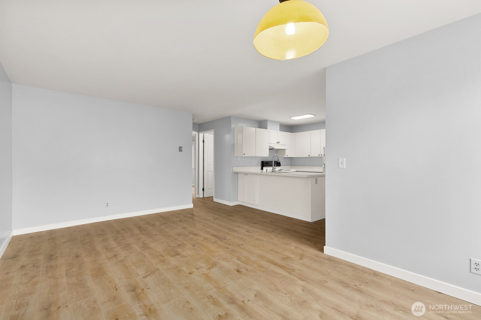 3660 Whitman Avenue North Seattle, WA 98103 - Photo 9 of 40 a view of kitchen and empty room with wooden floor