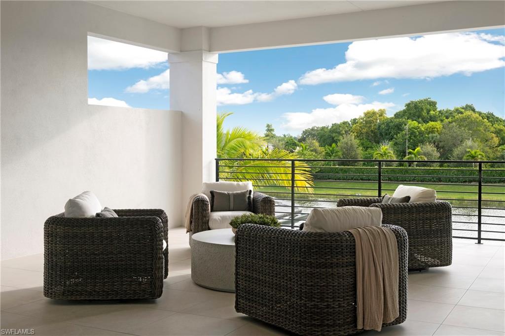 6704 Newport Road Naples, FL 34109 - Photo 31 of 47 a balcony with furniture and a floor to ceiling window