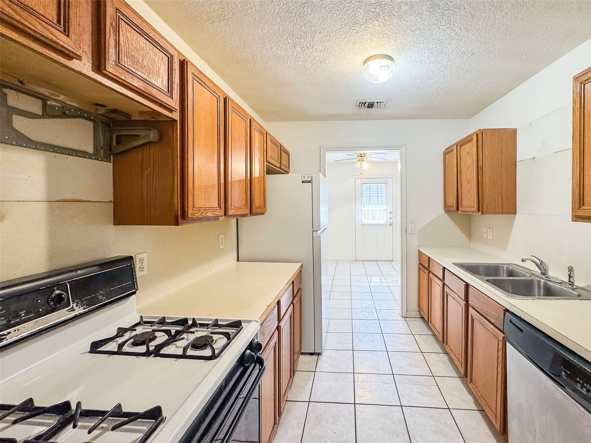 2006 Kilgore Road, Unit 101 Baytown, TX 77520 - Photo 12 of 20 a kitchen with stainless steel appliances a stove a sink and a refrigerator