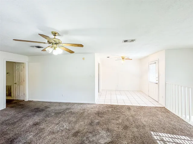 a view of a livingroom with a ceiling fan and window