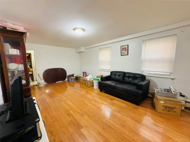 a living room with furniture a flat screen tv and a window