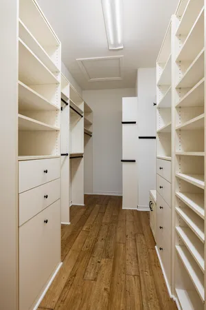 a view of walk in closet with empty racks