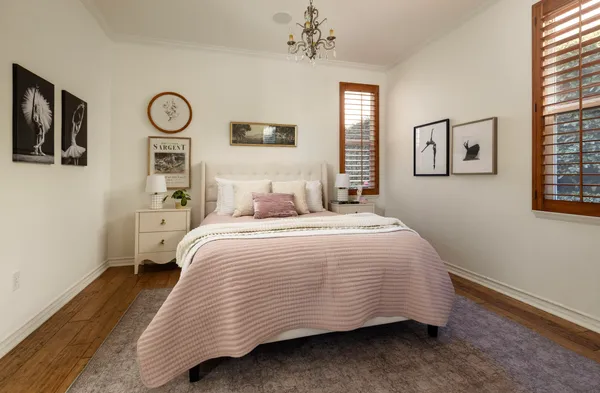 a bedroom with a bed and painting on the wall