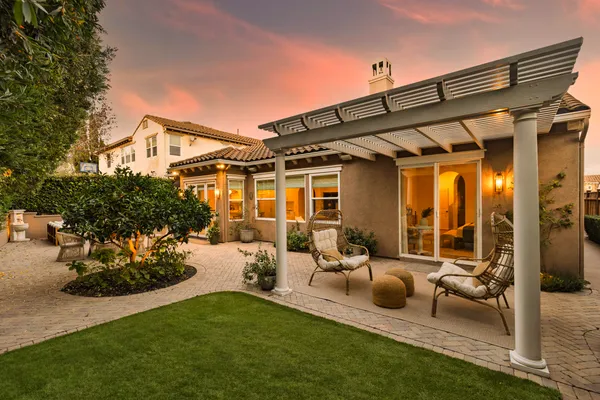 a view of a house with backyard sitting area and garden