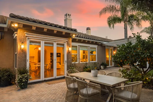 a view of a patio with a table and chairs and potted plants