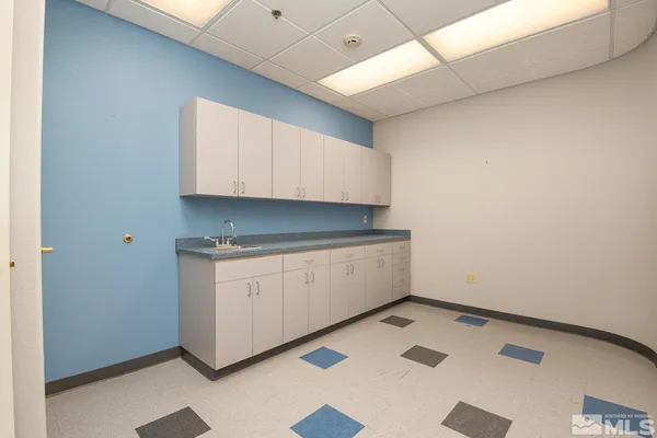 an empty room with cabinet and windows