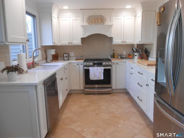 a kitchen with stainless steel appliances white cabinets and a sink