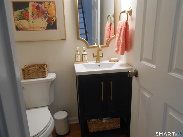 a bathroom with a toilet sink and mirror