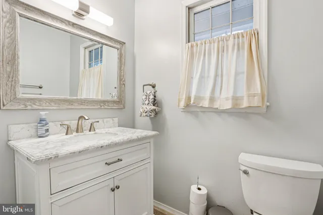 a bathroom with a granite countertop sink a toilet and shower