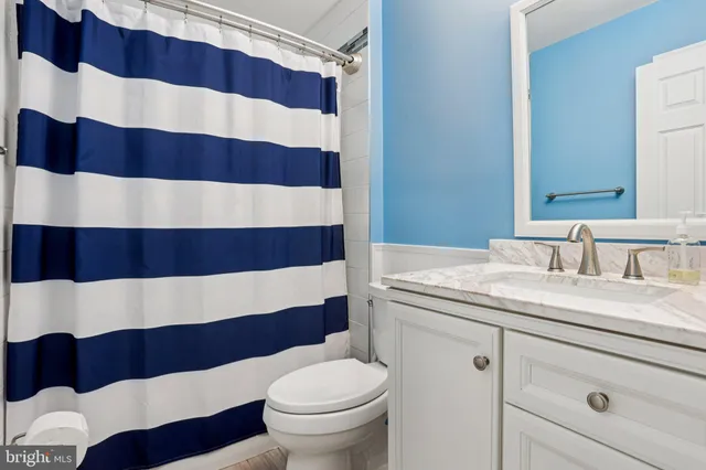 a front view of a house with swimming pool and large trees