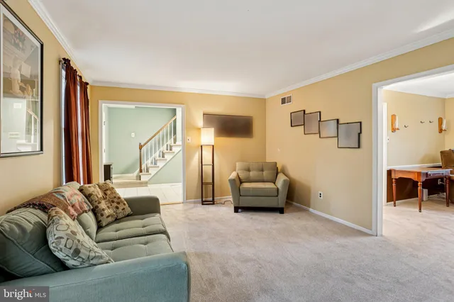 a living room with furniture a flat screen tv and kitchen view