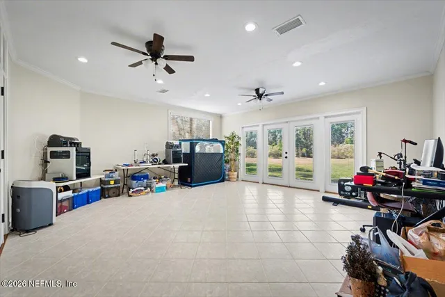 a view of a livingroom with furniture a ceiling fan a flat screen tv and a large window