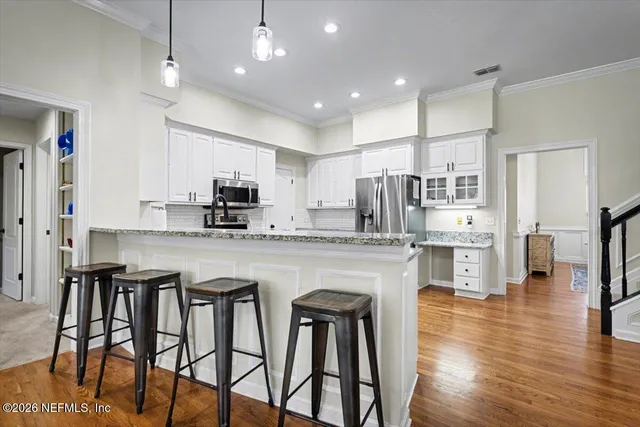 a kitchen with granite countertop a refrigerator and a stove top oven