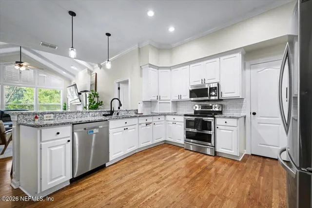 a large white kitchen with lots of counter space and a sink