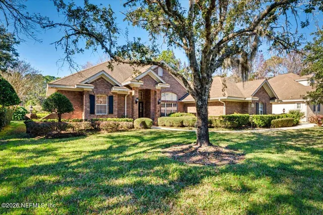 a front view of a house with yard and green space