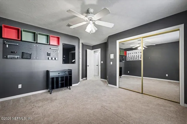 a view of an empty room with a chandelier fan