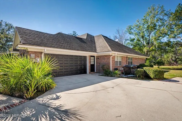a front view of a house with a yard and a garden
