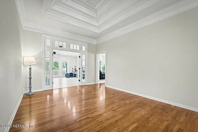 a view of empty room with wooden floor and windows