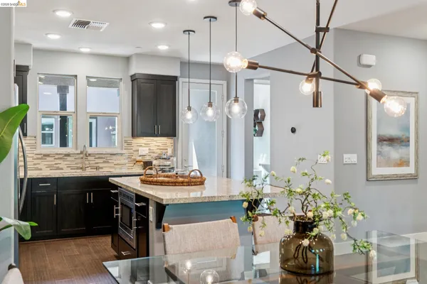 a kitchen with stainless steel appliances kitchen island a refrigerator and a dining table
