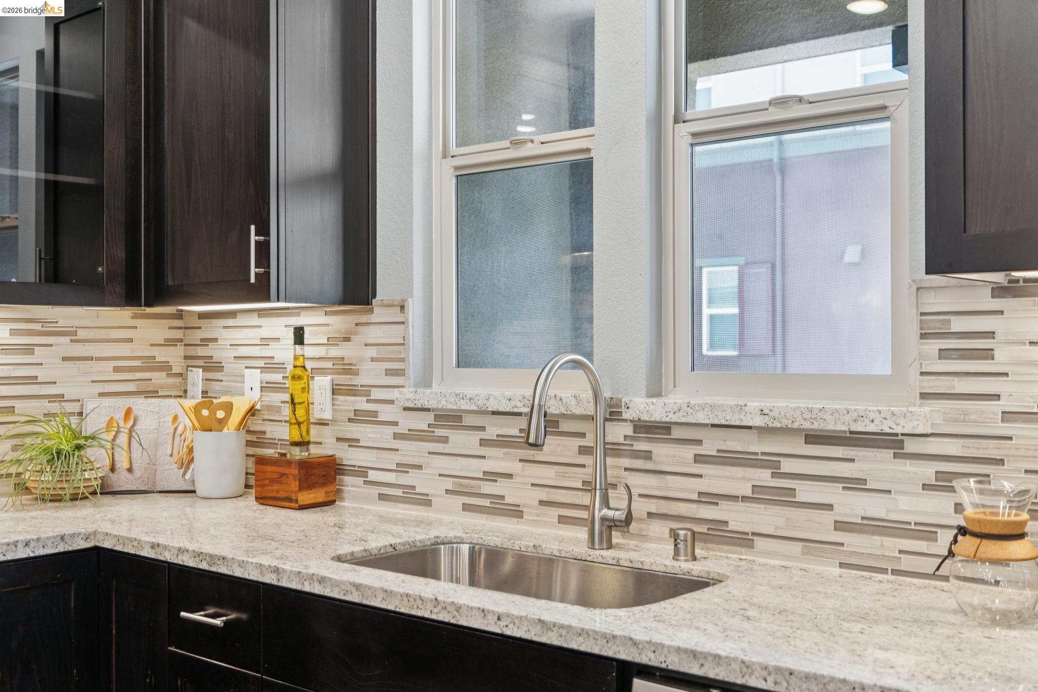 489 Diller Street Alameda, CA 94501 - Photo 17 of 60 Kitchen with light stone countertops, decorative backsplash, and dark wood finish cabinets
